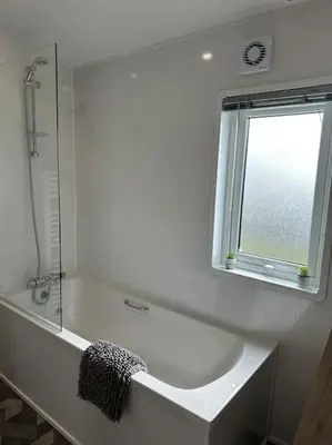 a bathroom with a bath tub and a window at Modern Lodge with Amazing Views in Newquay