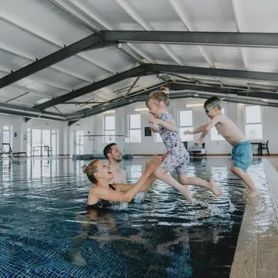 a group of people playing in a swimming pool at Modern Lodge with Amazing Views in Newquay