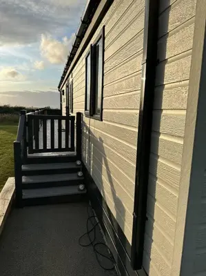 a porch of a house with a stairs on it at Modern Lodge with Amazing Views in Newquay