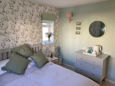 a bedroom with a bed and a mirror and a dresser at 5 SEAVIEW private parking w EV in Saint Mawes