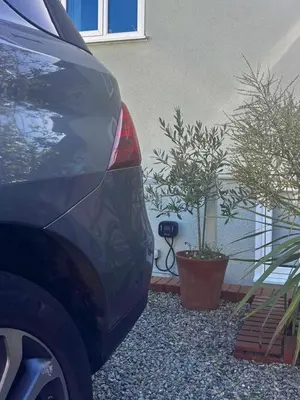a car parked next to a house with two potted plants at 5 SEAVIEW private parking w EV in Saint Mawes