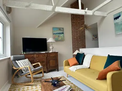a living room with a couch and a tv at 5 SEAVIEW private parking w EV in Saint Mawes