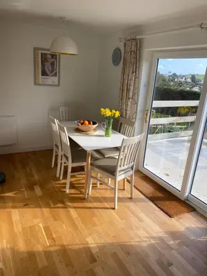 a dining room with a table and chairs and a window at 5 SEAVIEW private parking w EV in Saint Mawes