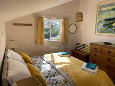 a bedroom with a bed and a dresser and a window at 5 SEAVIEW private parking w EV in Saint Mawes