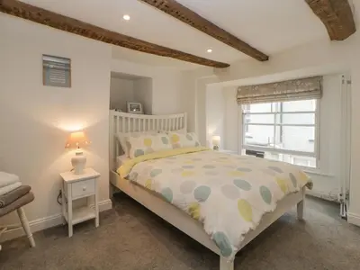 a bedroom with a bed and a window at Sun Cottage in Looe
