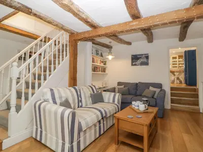 a living room with a couch and a table at Sun Cottage in Looe
