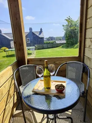 a table with two glasses and a bottle of wine at Little Swelle Cabin with awesome Sea views in Poundstock
