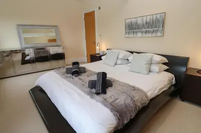 a bedroom with a large white bed with pillows at The Penthouse in Helston