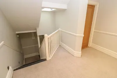 an empty room with stairs and a stair case at The Penthouse in Helston