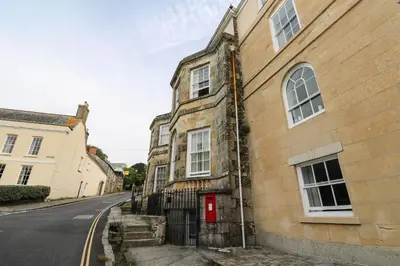 an old building with a red door on a street at The Penthouse in Helston