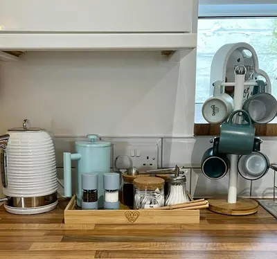a kitchen counter with a tray full of utensils at Nook Cottage Seaside Charm & Countryside Calm in Newquay