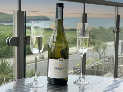 a bottle of wine sitting on a table with two glasses at 24 Zinc in Newquay
