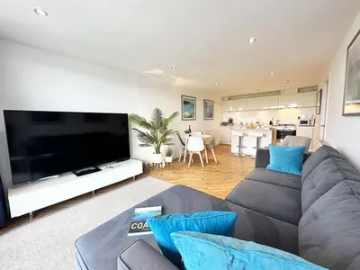 a living room with a couch and a large flat screen tv at 24 Zinc in Newquay