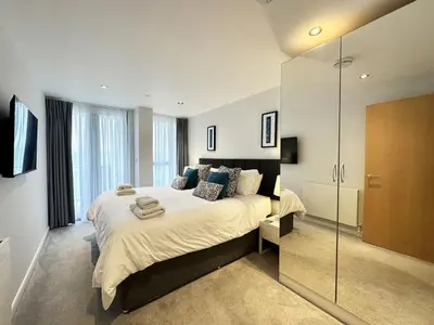 a bedroom with a large bed and a glass shower at 24 Zinc in Newquay