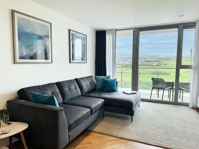 a living room with a couch and a large window at 24 Zinc in Newquay