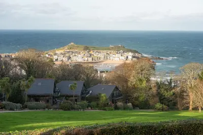 a group of houses on a hill next to the ocean at St Ia, Castle Approach, Tregenna Castle in St Ives