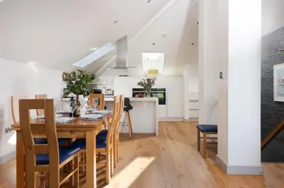 a kitchen and dining room with a wooden table and chairs at St Ia, Castle Approach, Tregenna Castle in St Ives