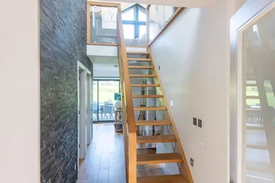 a wooden staircase in a room with a brick wall at St Ia, Castle Approach, Tregenna Castle in St Ives