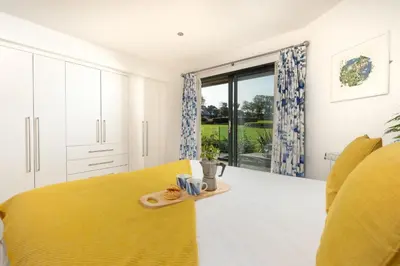 a bedroom with a yellow bed and a tray of food at St Ia, Castle Approach, Tregenna Castle in St Ives