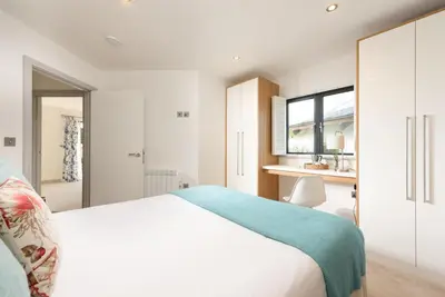 a bedroom with a bed and a desk and a window at St Ia, Castle Approach, Tregenna Castle in St Ives