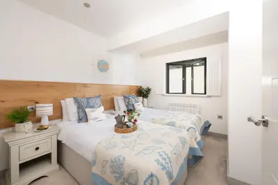 a bedroom with two beds and a window at St Ia, Castle Approach, Tregenna Castle in St Ives