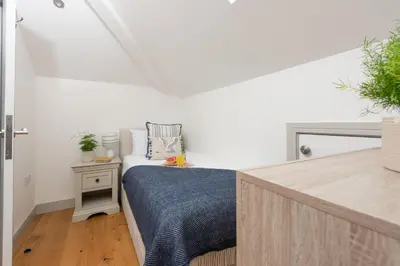 a bedroom with a bed with a blue blanket at St Ia, Castle Approach, Tregenna Castle in St Ives