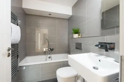 a bathroom with a sink and a tub and a toilet at St Ia, Castle Approach, Tregenna Castle in St Ives