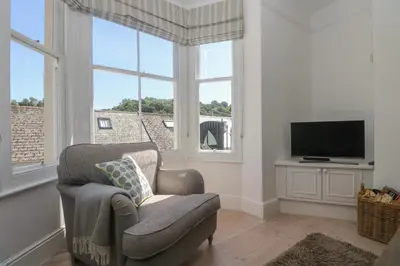 a living room with a chair and a television at 21 Passage Street formerly Panacea in Fowey