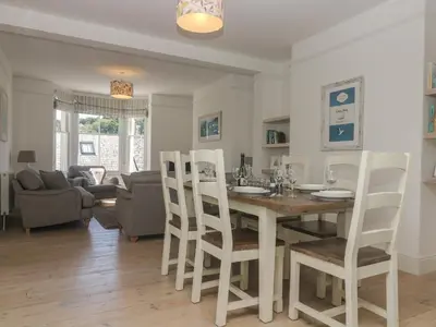 a dining room and living room with a table and chairs at 21 Passage Street formerly Panacea in Fowey