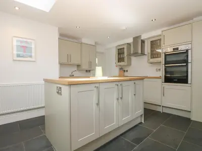 a kitchen with white cabinets and a counter top at 21 Passage Street formerly Panacea in Fowey