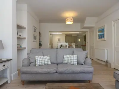 a living room with a gray couch with two pillows at 21 Passage Street formerly Panacea in Fowey