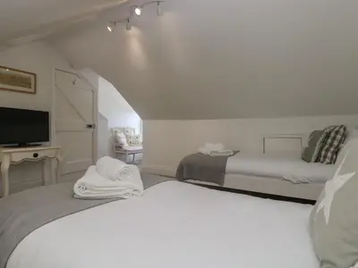a bedroom with two beds and a tv in a room at 21 Passage Street formerly Panacea in Fowey