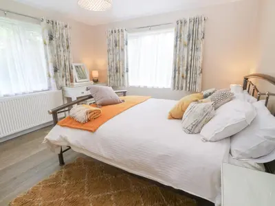 a bedroom with a large white bed with pillows at Little Roskrow in Penryn