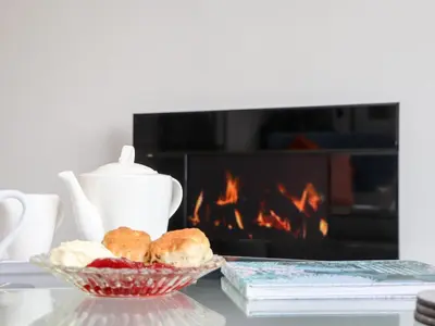 a table with a bowl of food and a fireplace at Little Roskrow in Penryn