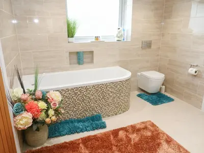 a bathroom with a bath tub and a toilet at Little Roskrow in Penryn