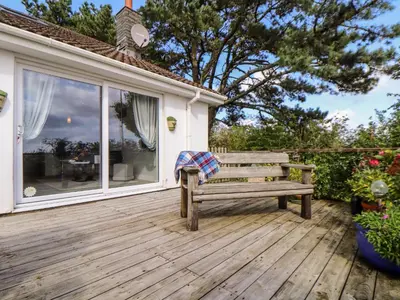 a wooden bench sitting on a wooden deck at Little Roskrow in Penryn