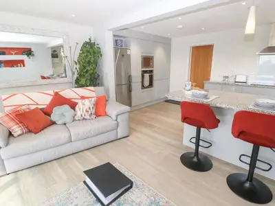a living room with a couch and a kitchen at Little Roskrow in Penryn