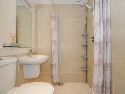 a bathroom with a toilet and a sink and a shower at Little Trevallan in Looe