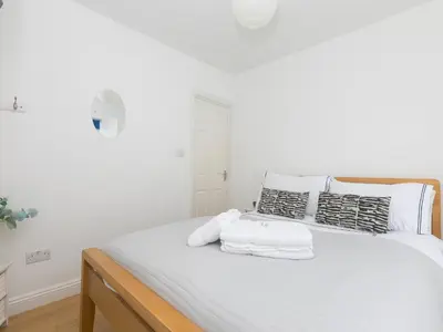 a bedroom with a bed with white sheets and pillows at 5 St Brigids in St Ives