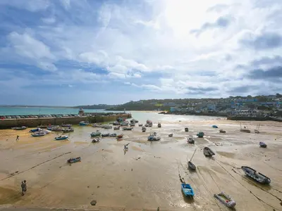 a beach with boats and people on the sand at 5 St Brigids in St Ives