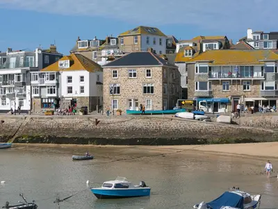 a group of boats in the water with buildings at 5 St Brigids in St Ives