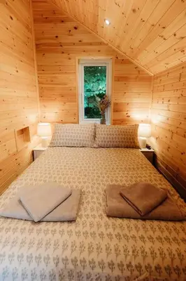 a bedroom with a bed in a wooden cabin at Riverside Retreats - Steamers Meadow in Gwinear
