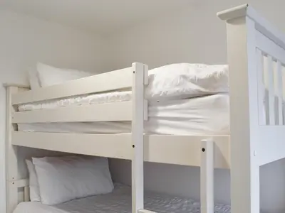 a white bunk bed with white sheets and pillows at Eighty Two in Newquay