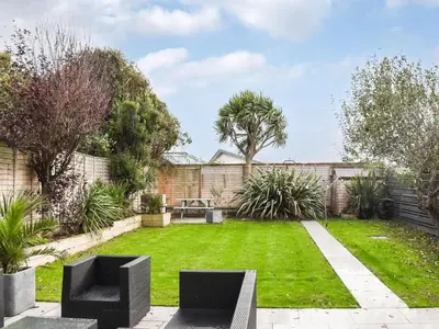 a garden with two black chairs in the grass at Eighty Two in Newquay