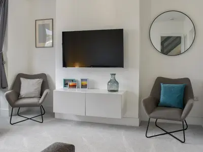 a living room with two chairs and a tv at Eighty Two in Newquay
