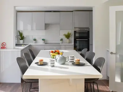 a kitchen with a table with a bowl of fruit on it at Eighty Two in Newquay