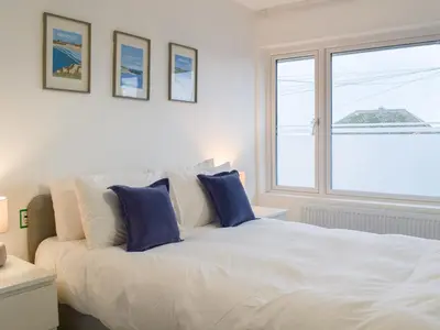 a bedroom with a large white bed with blue pillows at Eighty Two in Newquay