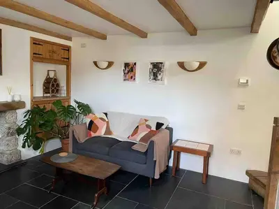 a living room with a blue couch and a table at 9A Viaduct Cottage - the cosiest bolthole in the SW! in Hayle