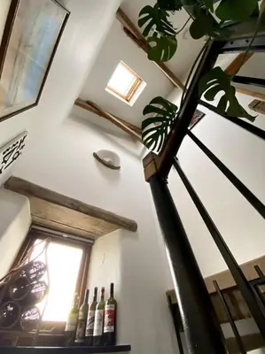 a room with a staircase with bottles of wine at 9A Viaduct Cottage - the cosiest bolthole in the SW! in Hayle