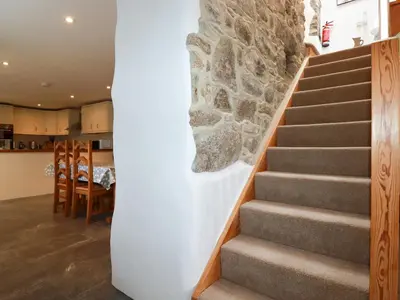 a staircase in a house with a stone wall at The Orchard in Bodmin